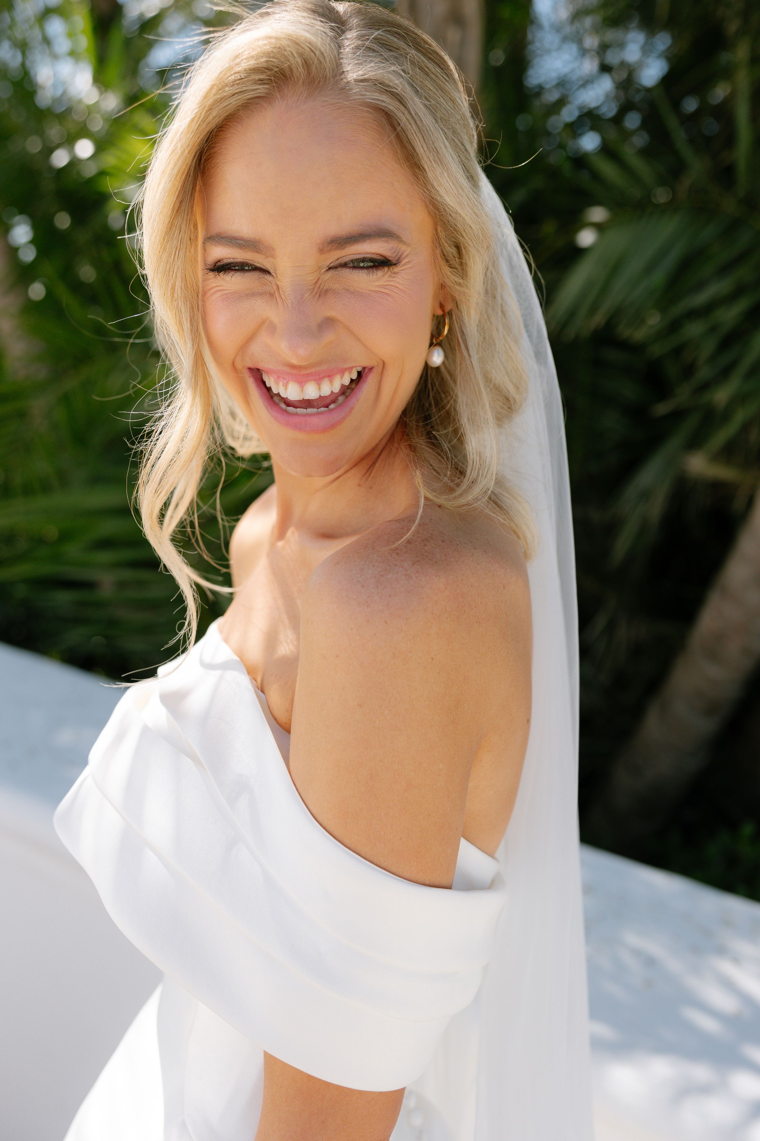 A joyful bride wearing a white dress laughs candidly in a series of five close-up photos outdoors.