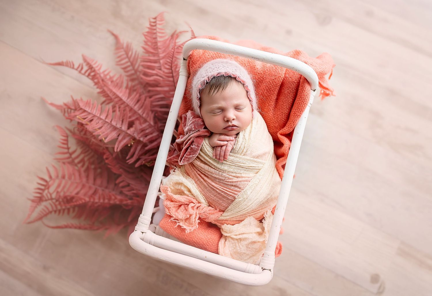 Bebe recien nacida en camita con colores corales Fotografa de newborn en Ponce, Fotografa de bebes en puerto rico