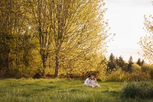 Golden autumn trees line a peaceful walking path in a natural park setting during sunset.