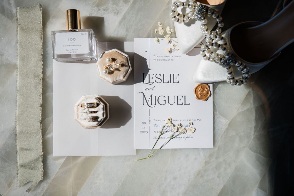 Elegant wedding place cards with names displayed on marble surface with dried flowers.