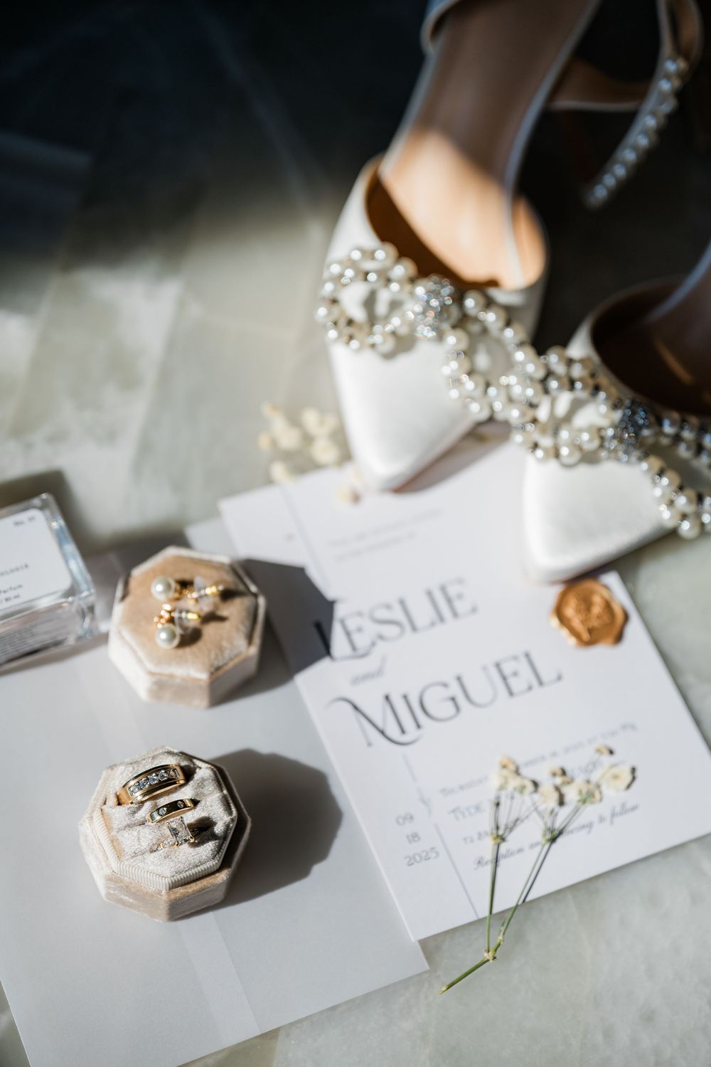 Wedding place cards and decorative elements with names and jewelry details on white surface.
