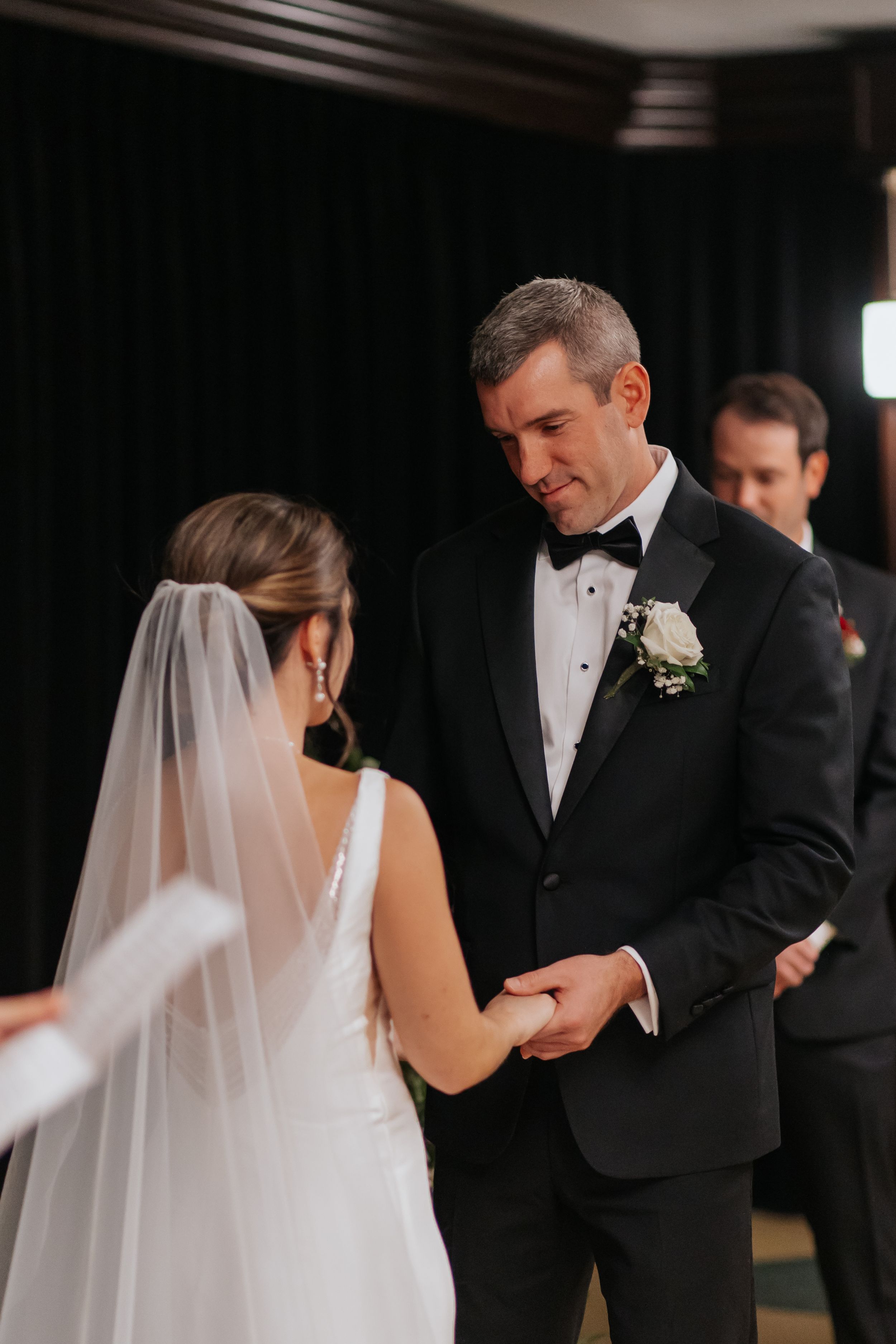 Intimate first look moment between bride and groom in formal attire during wedding ceremony.