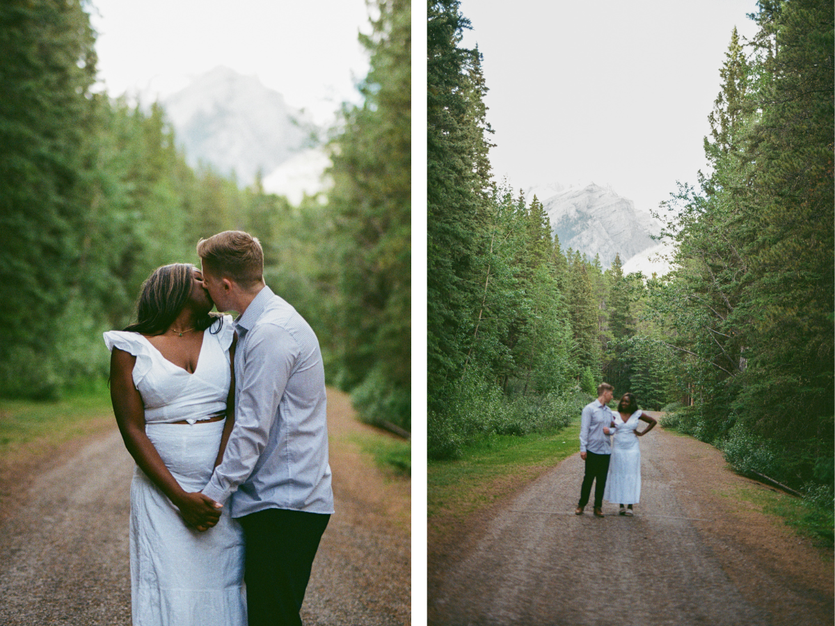 35 mm film photo of bride and groom kissing on a dirt path surrounded by tall evergreen trees during their Banff elopement