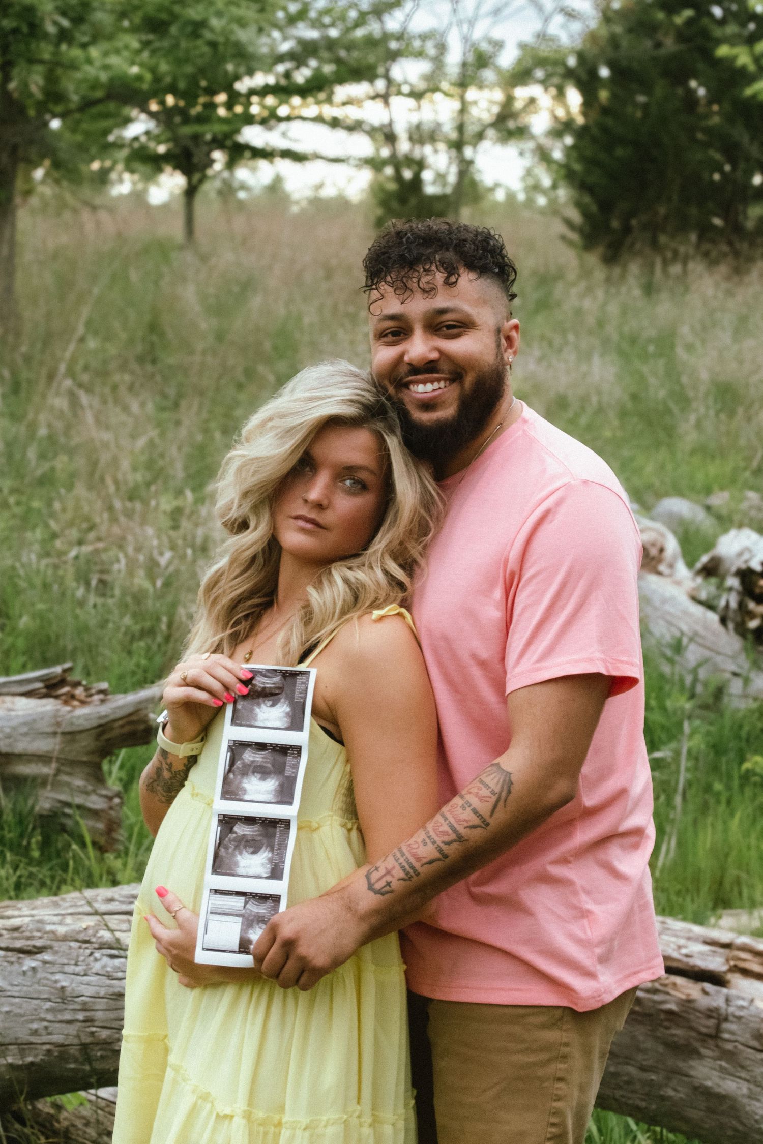 a couple holding their baby's ultrasound pictures
