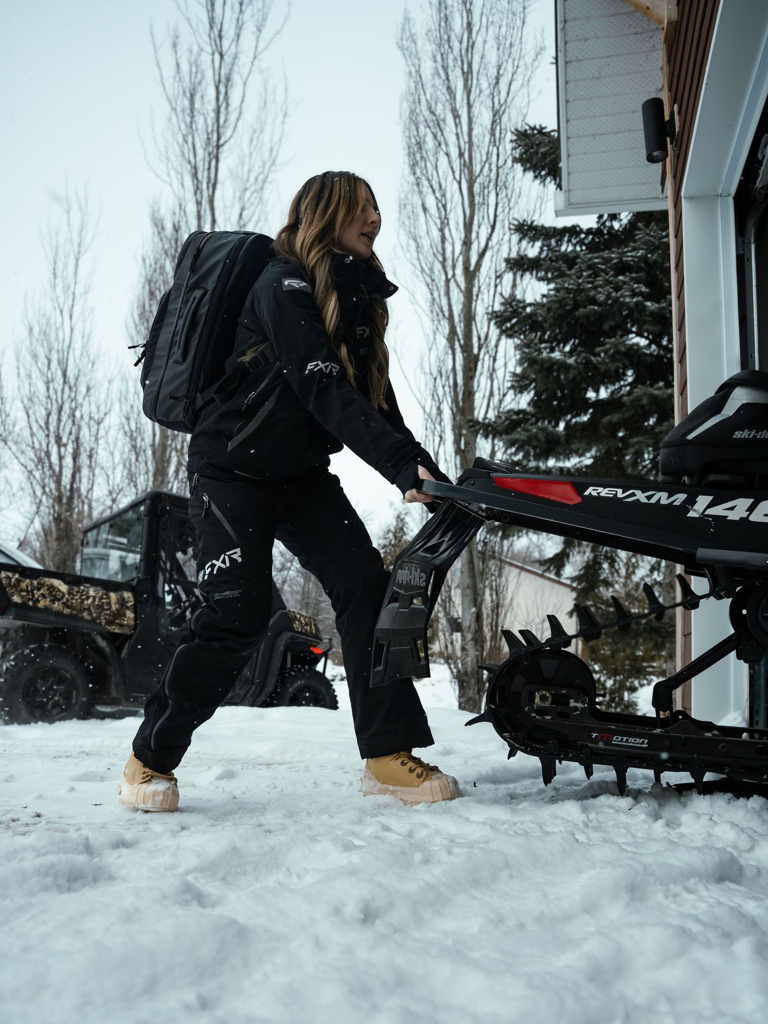 Winter sports gear being loaded onto snow-covered equipment rack.