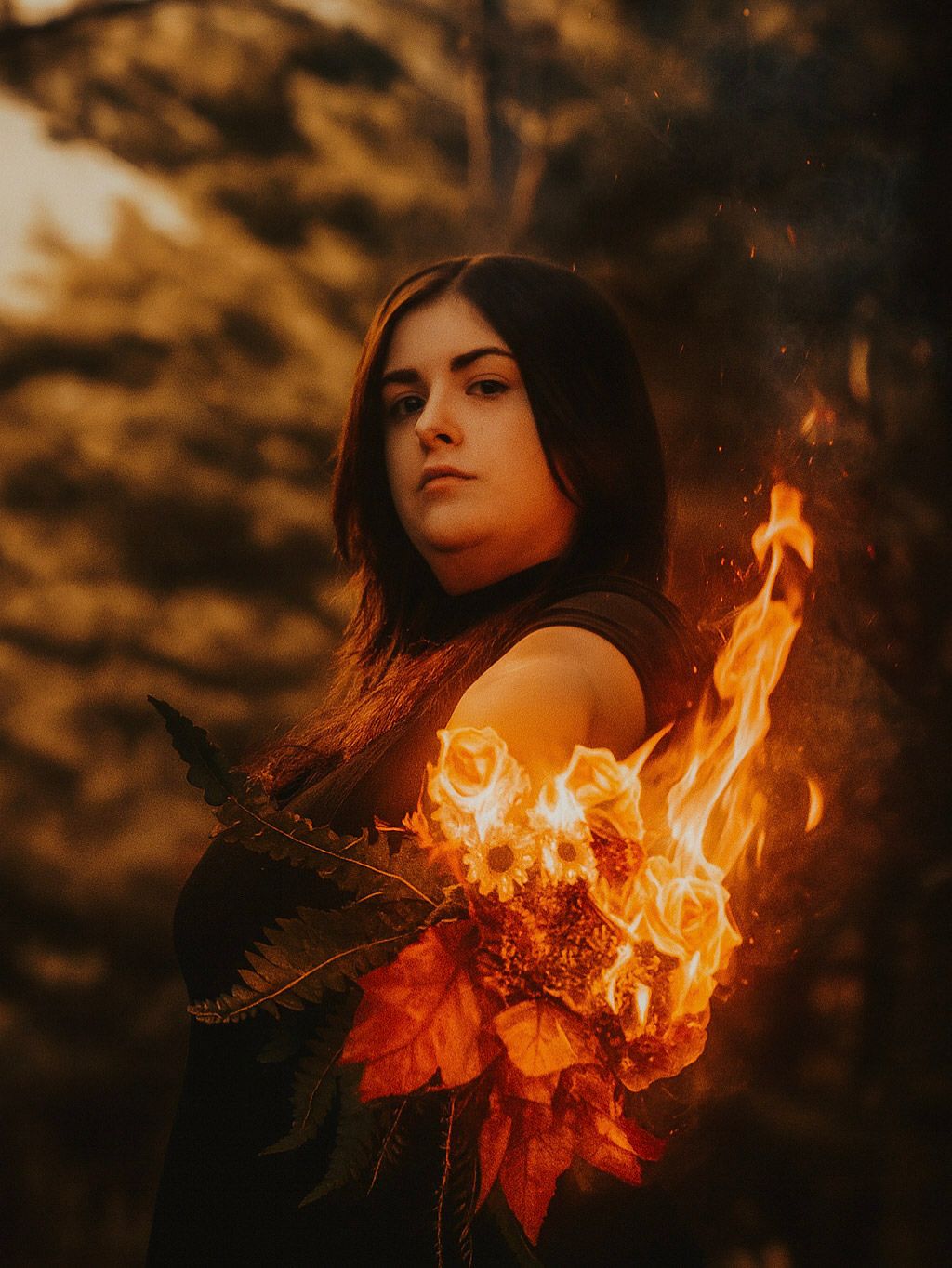 Artistic portrait in warm autumn tones featuring burning autumn leaves and flames against a golden sunset background.