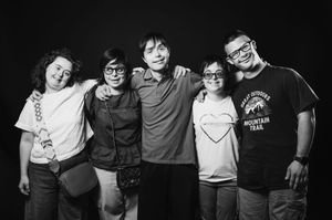 Foto di gruppo in bianco e nero di cinque persone che sorridono insieme.