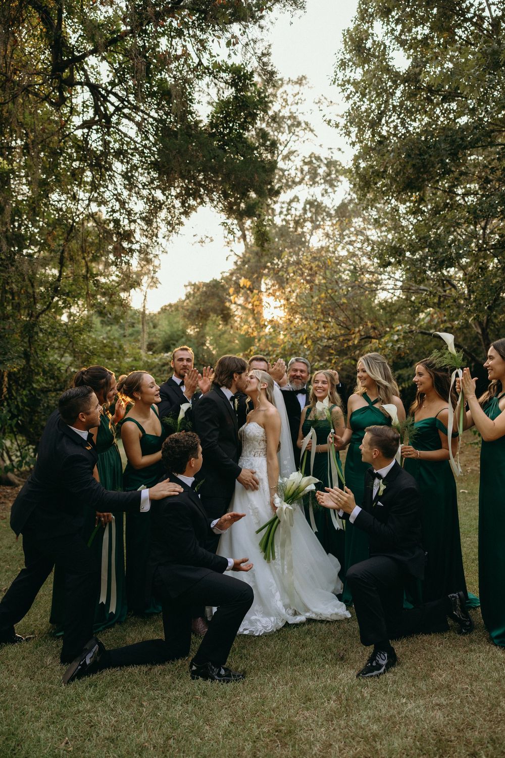 Wedding party celebrates during outdoor wedding party portraits at sunset at The Elms of Coosada in Coosada, Alabama