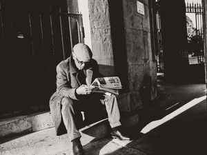 Man reading a newspaper in Parc Monceau, 8th arrondissement, Paris, France. 2024