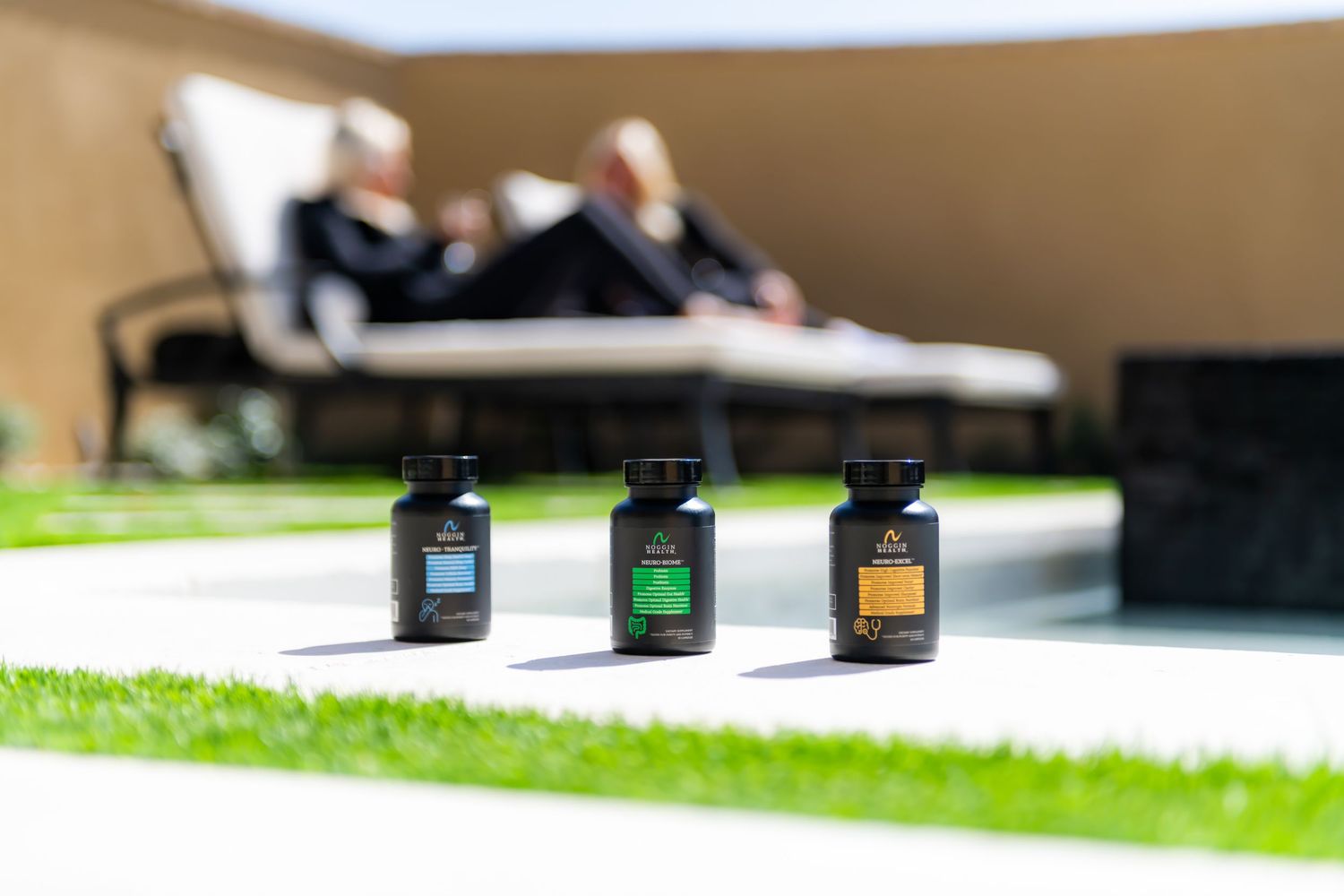 Several small bottles of CBD oil products arranged on a green grass surface in outdoor lighting.