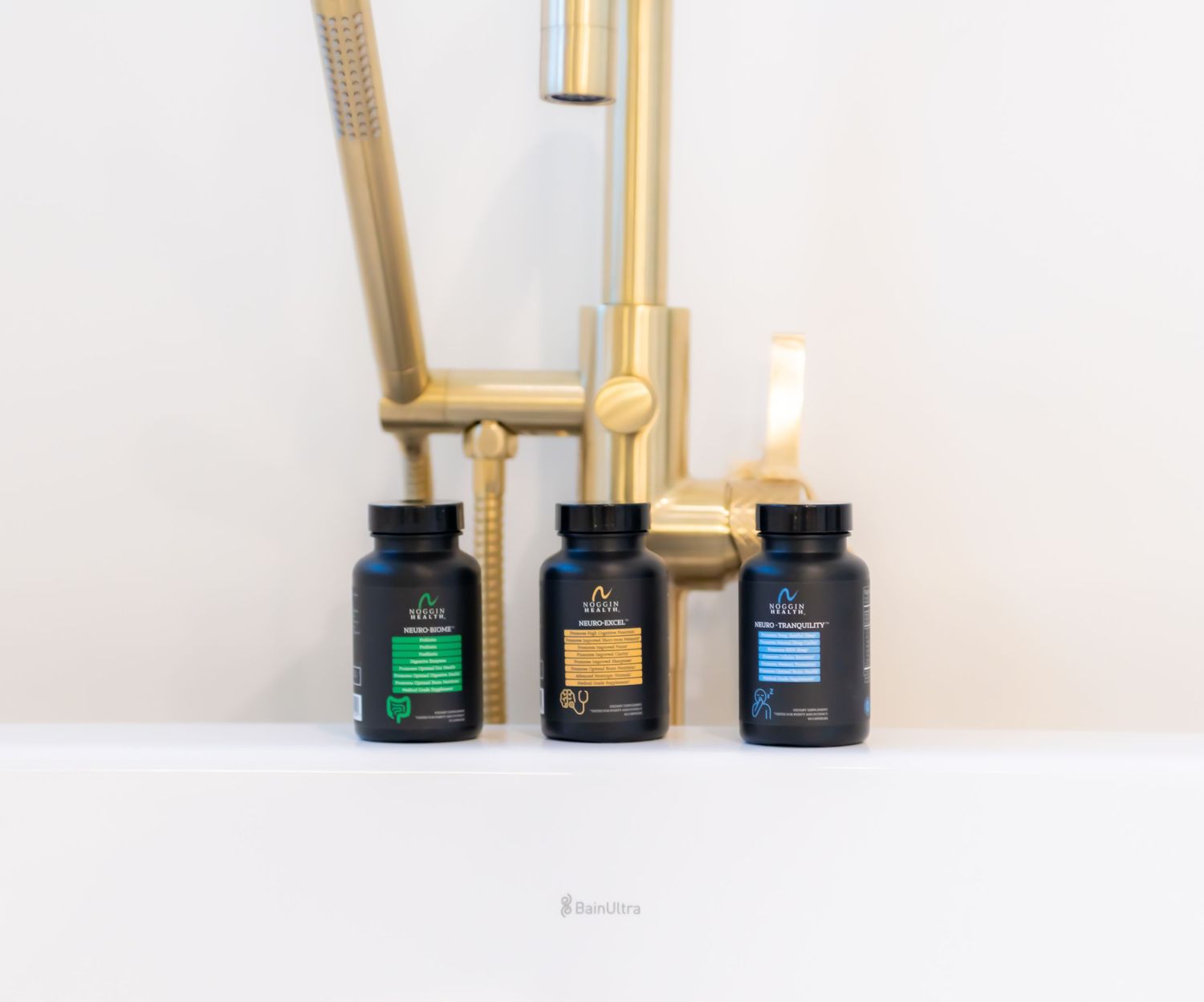 Three reed diffuser bottles with bamboo sticks and colorful liquids arranged on a white surface against a light background.