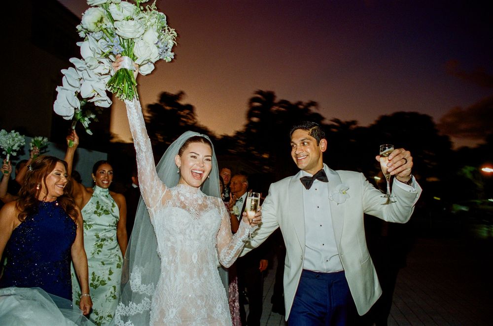 Wedding party dances and celebrates together during sunset reception outdoors.