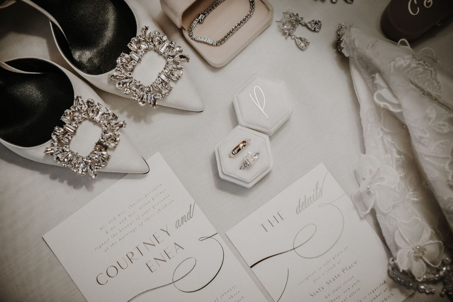 A collection of neutral wedding stationery with elegant script typography and delicate floral details arranged on a light surface.