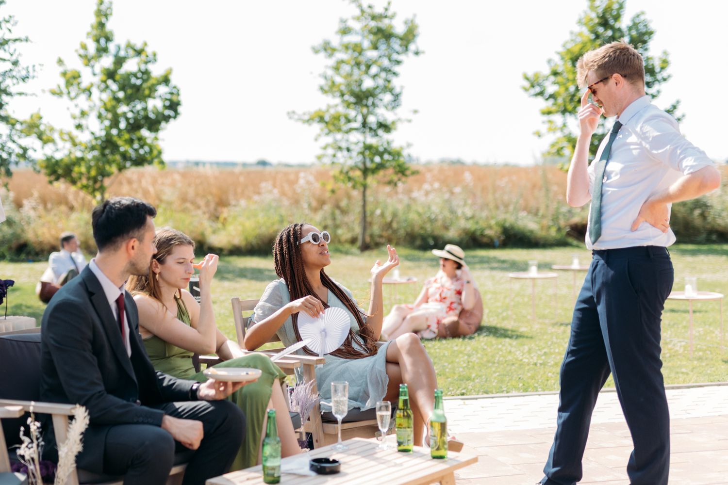 Wedding guests enjoy outdoor cocktail hour at elegant garden reception.
