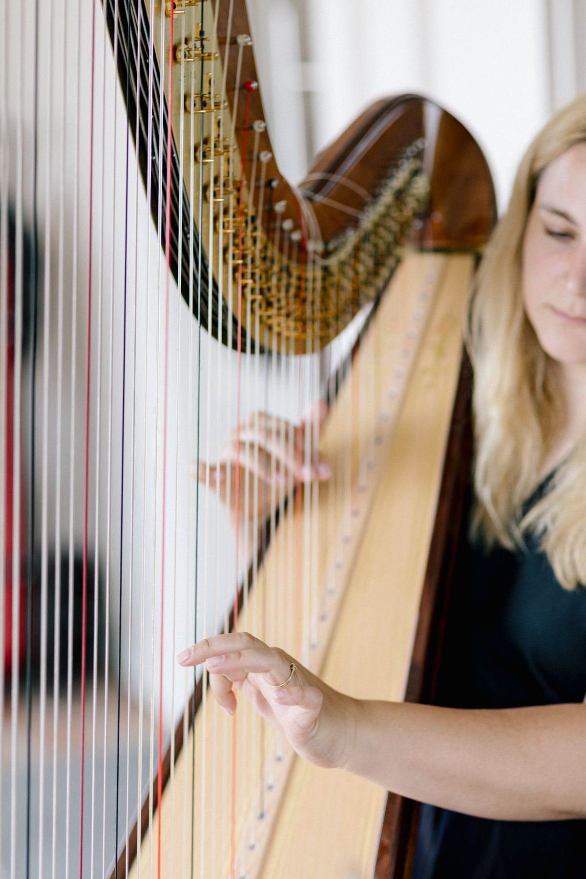 Close-up of harpist performing at elegant wedding ceremony.