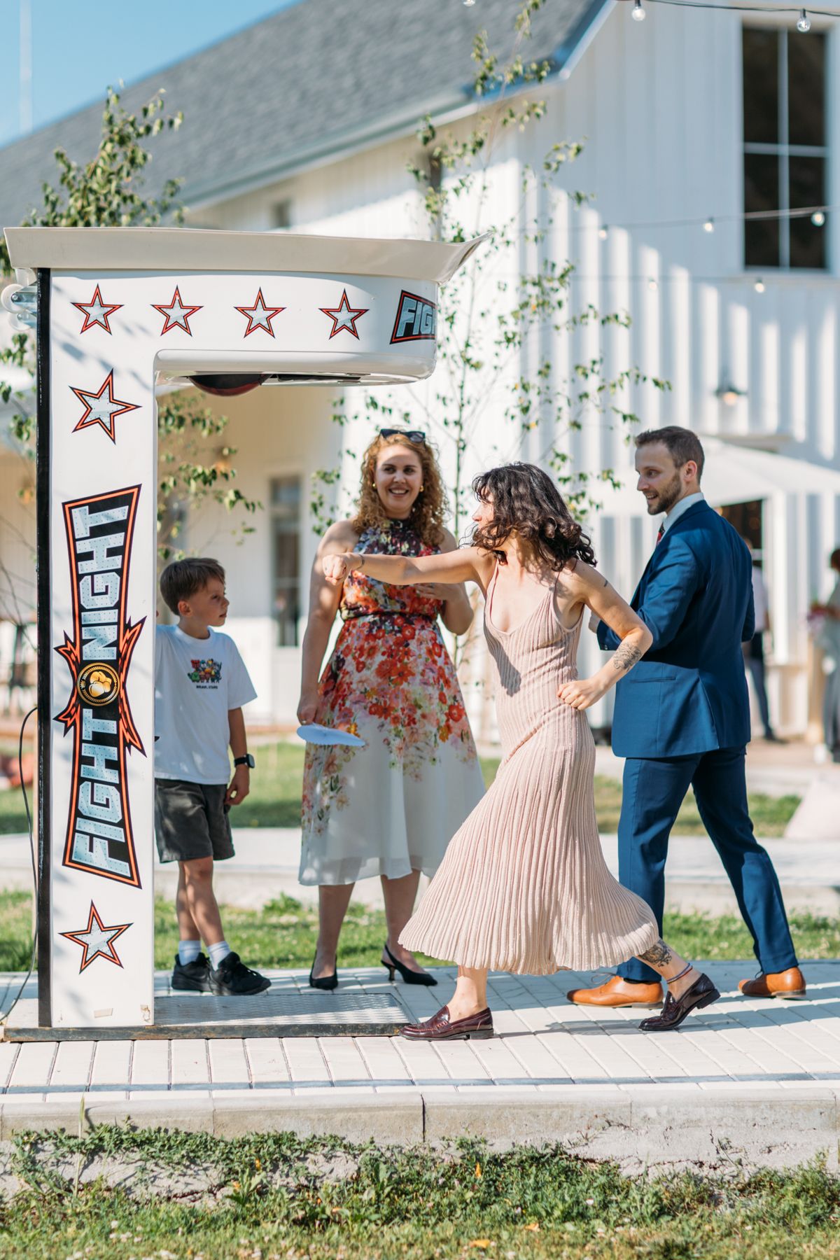 Wedding guests and children playing outdoor games on white platform.