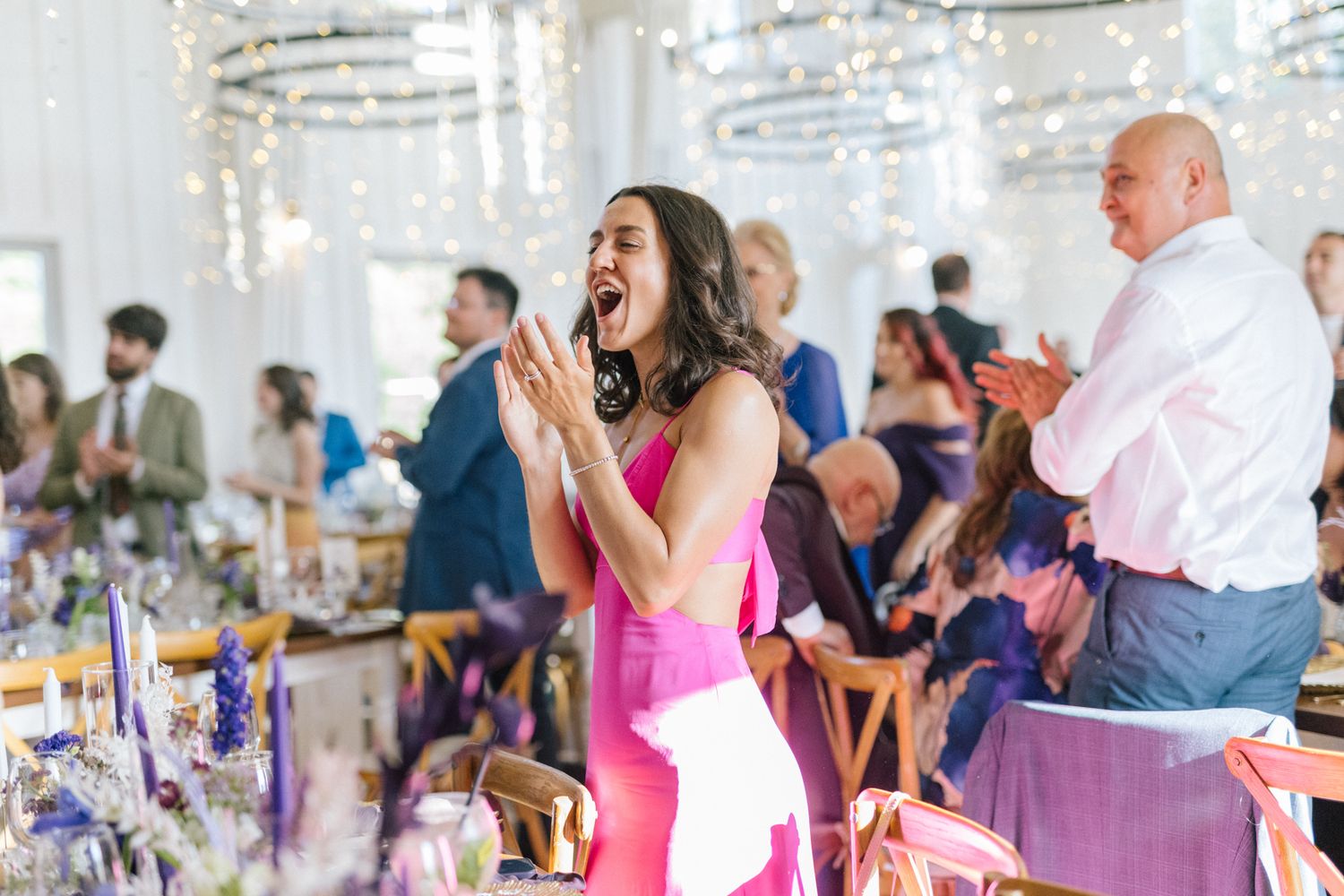 Wedding guests seated at decorated reception tables enjoying the celebration.