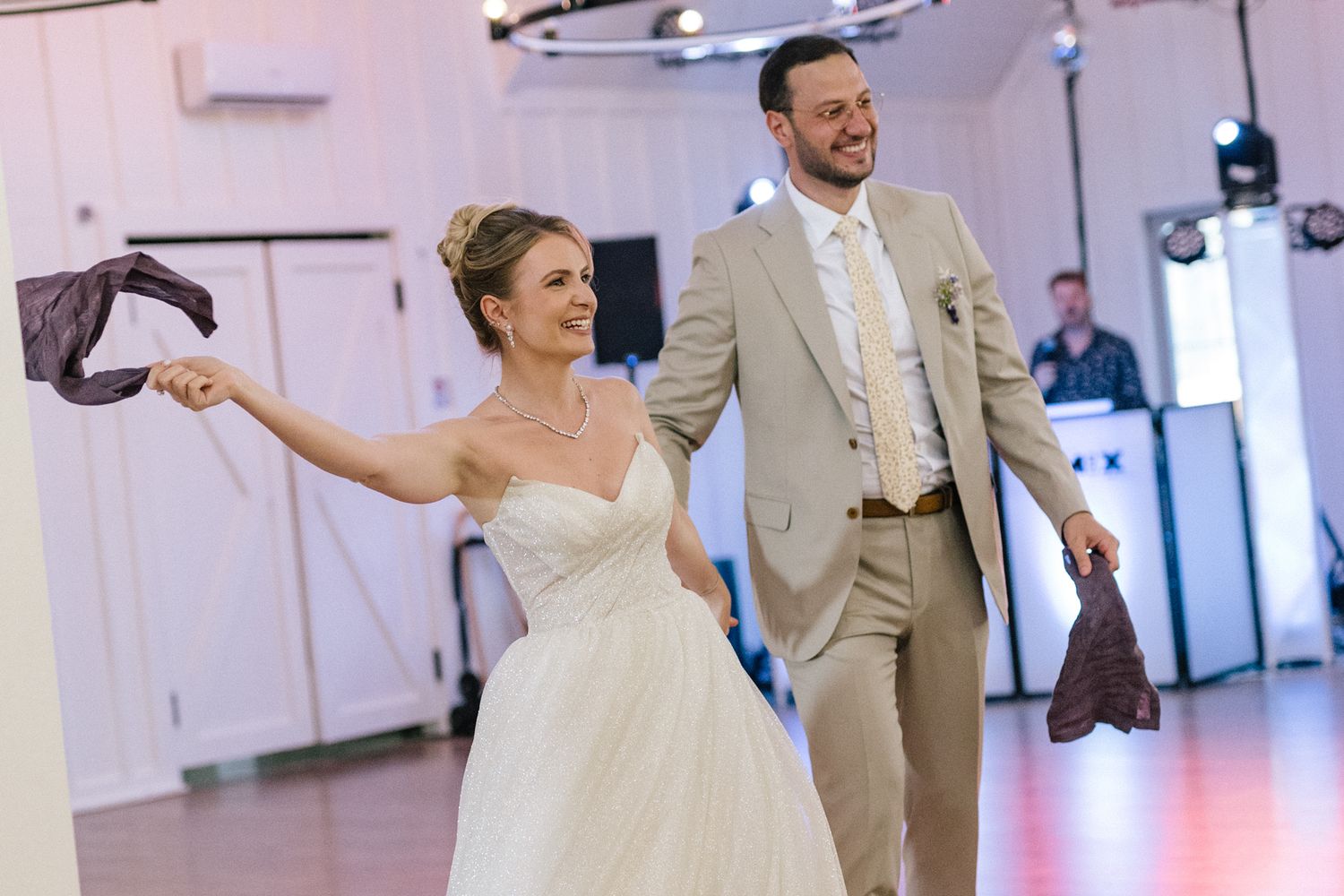 Couples dancing together during a wedding reception in a bright indoor venue.