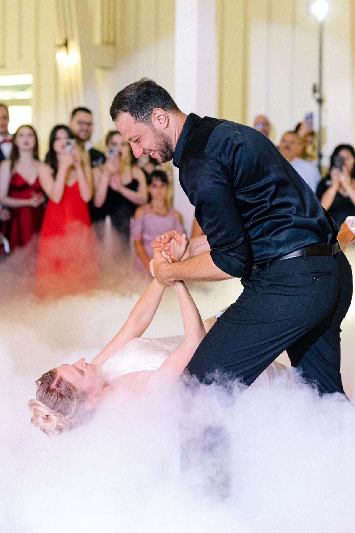 Dramatic dance performance with fog effects on a white dance floor.