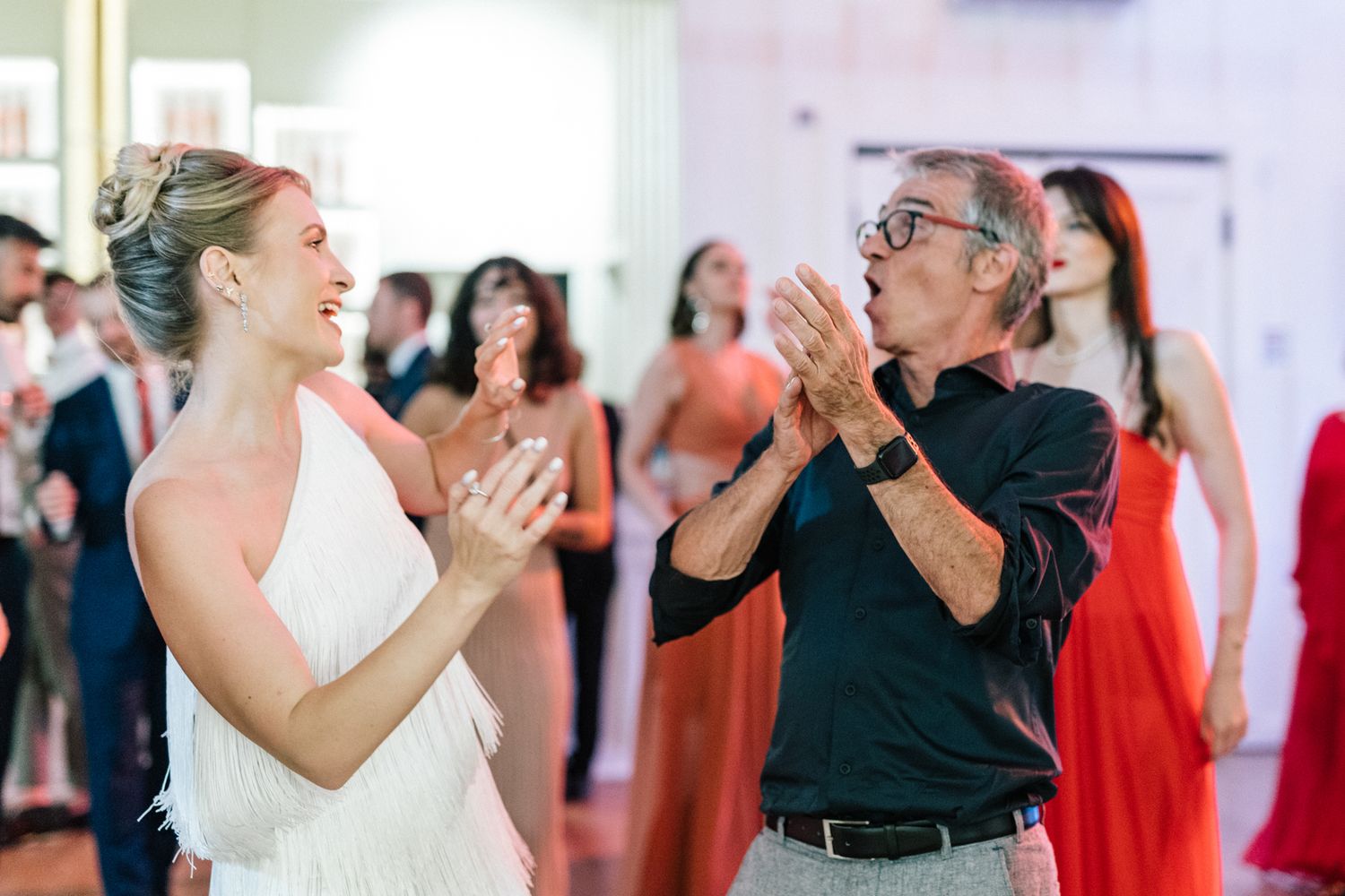 Dancers practicing in a bright studio with red and black outfits.