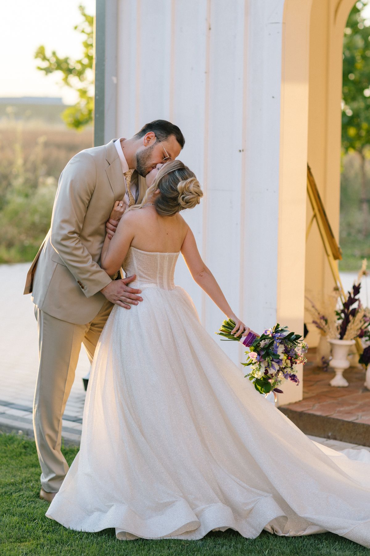 Newlyweds dancing gracefully on a porch with flowing white wedding dress.