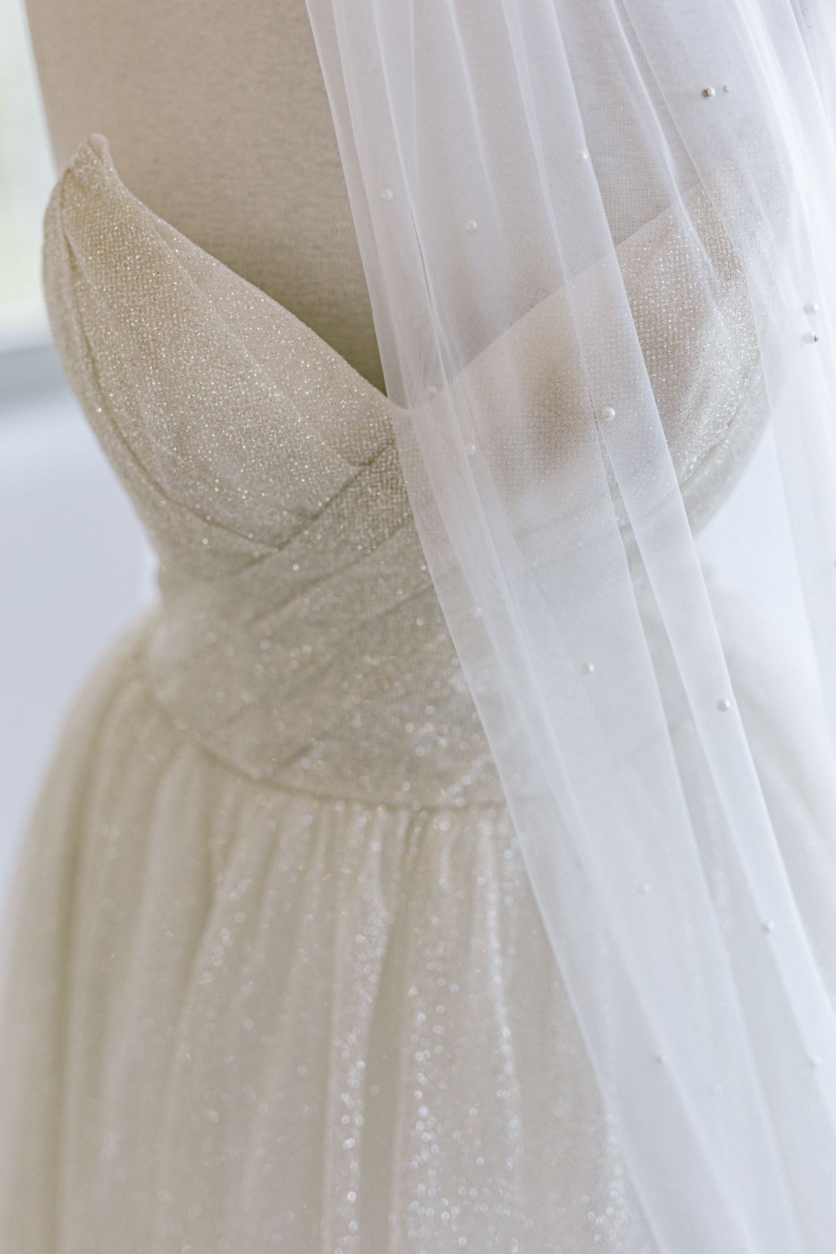 Close-up detail of a white wedding dress with delicate tulle fabric.