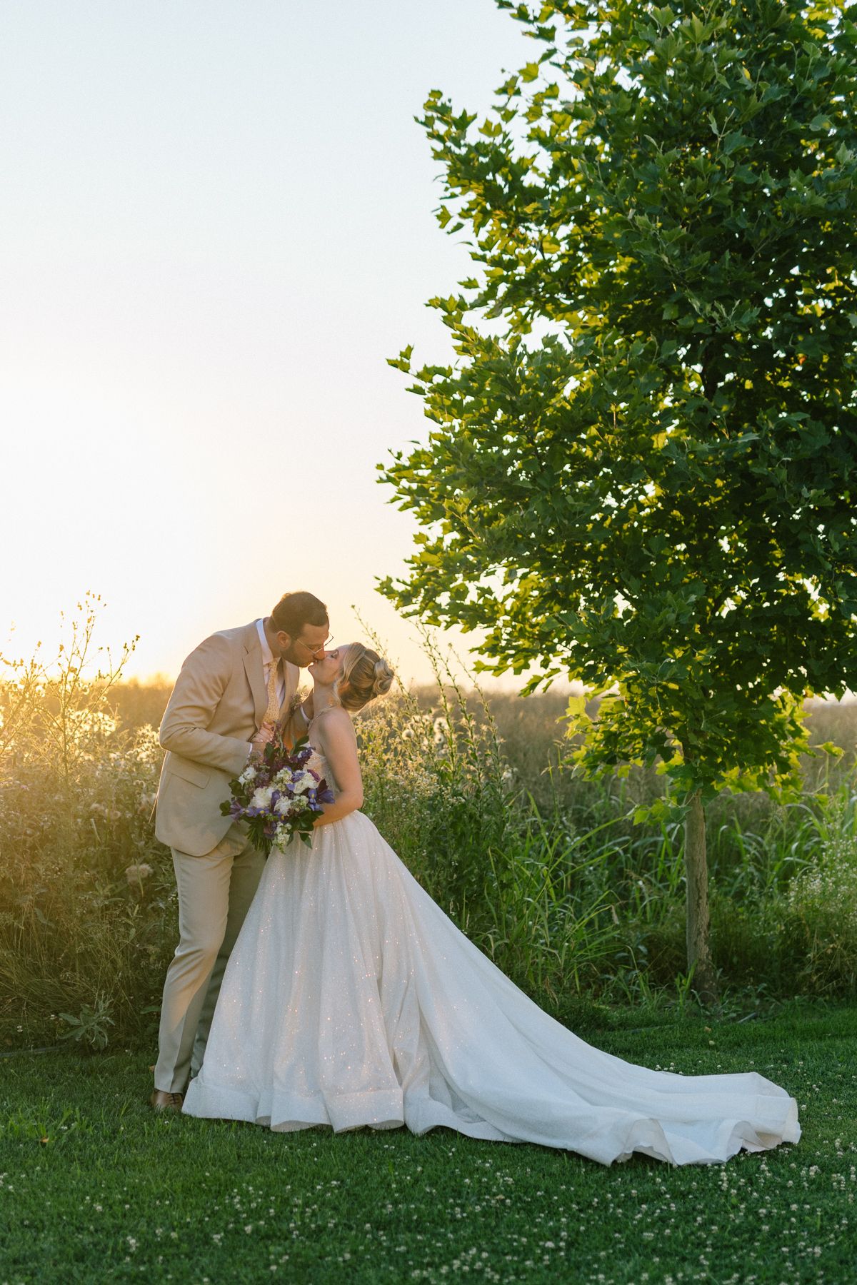 Romantic wedding portraits captured in a lush garden setting at sunset.