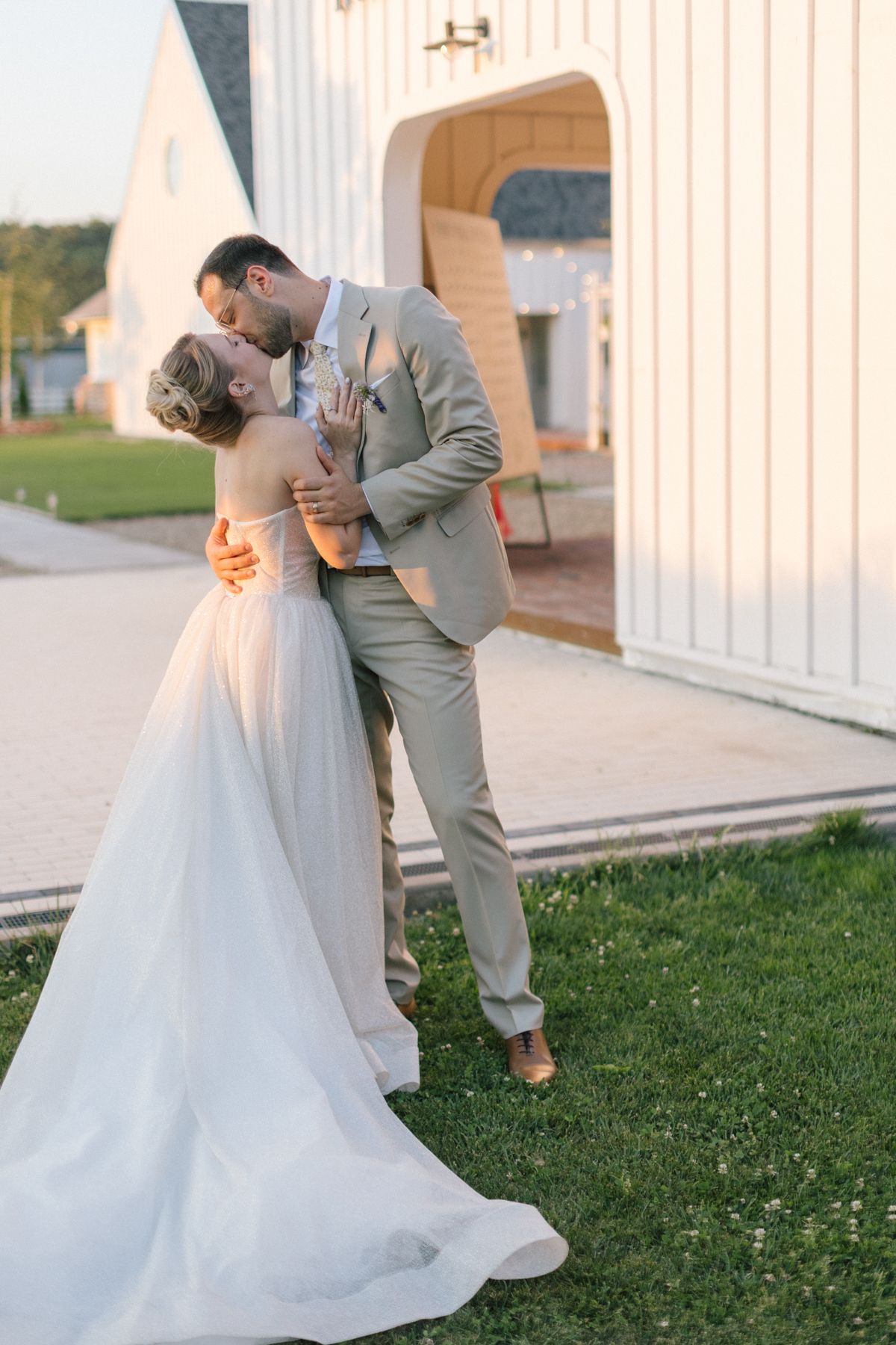 A wedding couple shares a romantic moment outside The White Manor building.