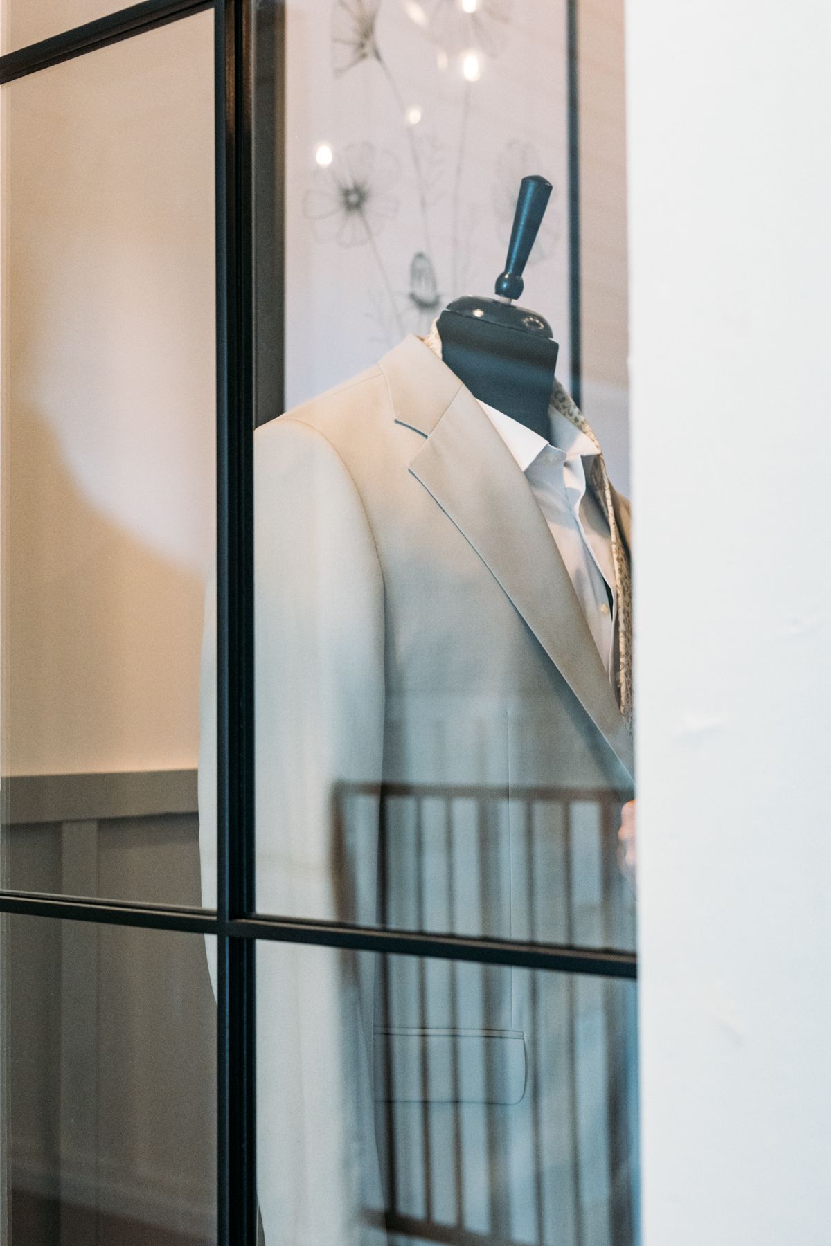 A white dress shirt hangs on a mannequin form in a clothing store display.