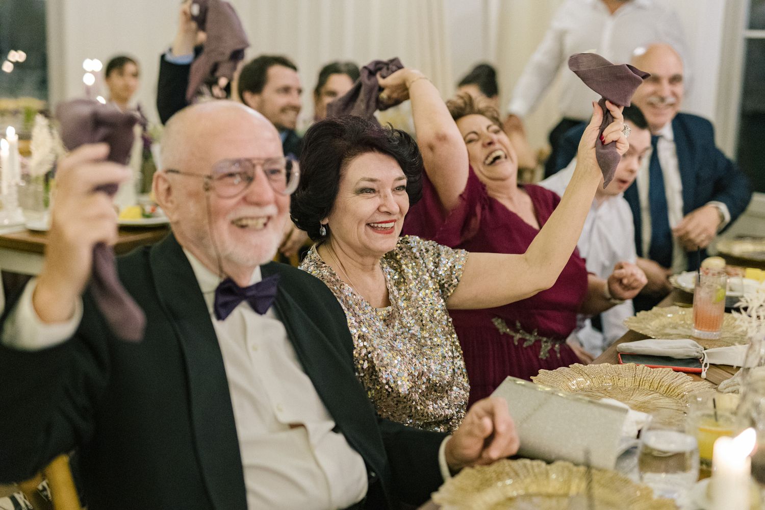 Wedding guests sharing laughter and joy during an elegant reception dinner.