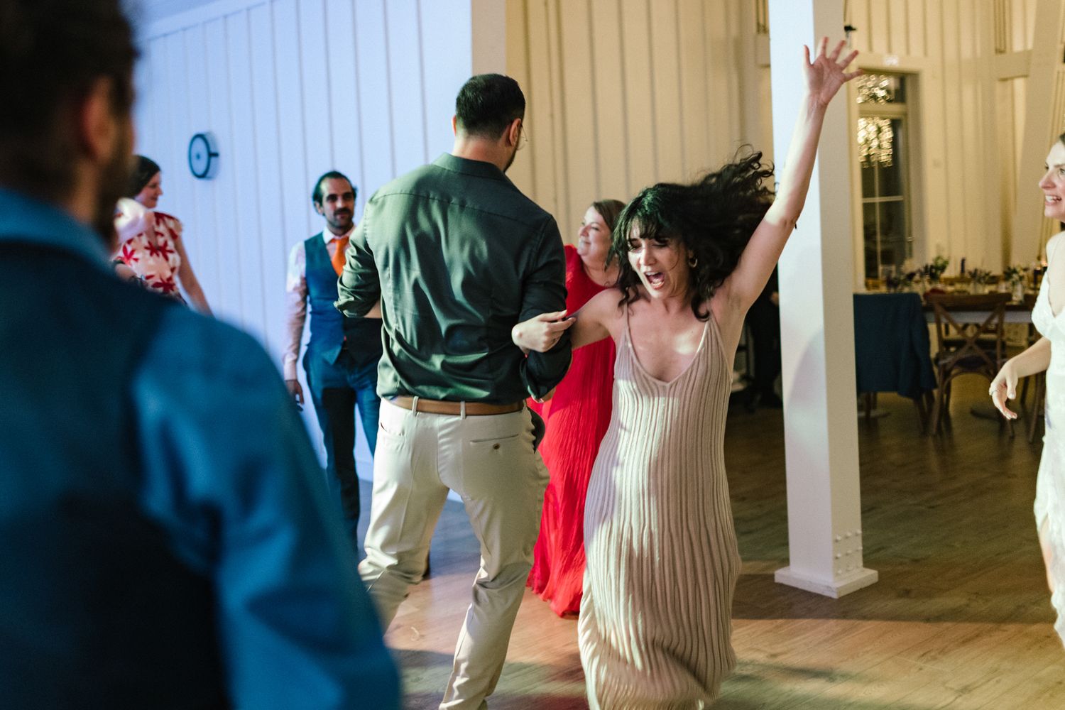 Wedding reception dance floor filled with guests enjoying lively celebration.