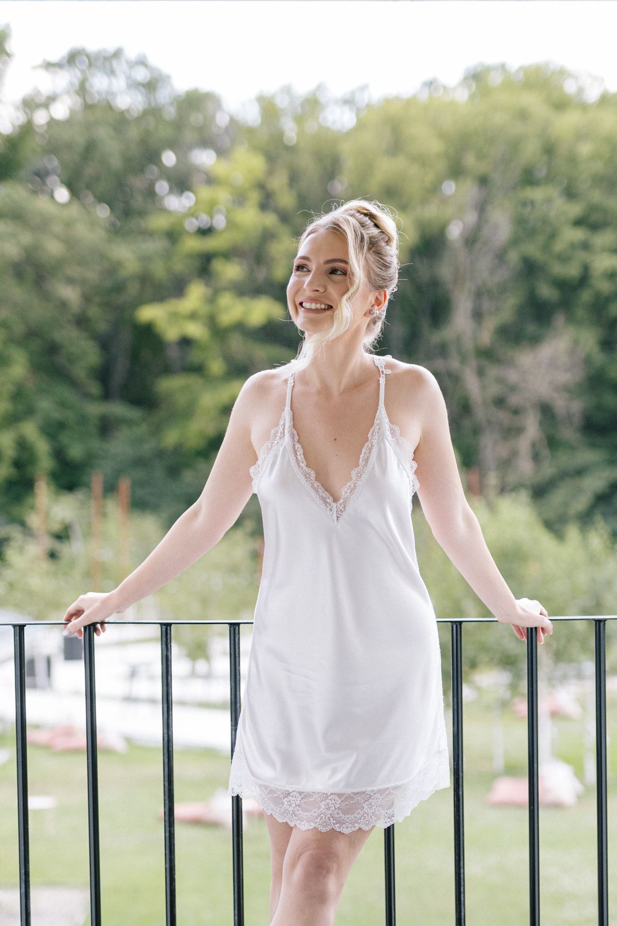 Multiple shots of person in white lace dress leaning against outdoor railing.