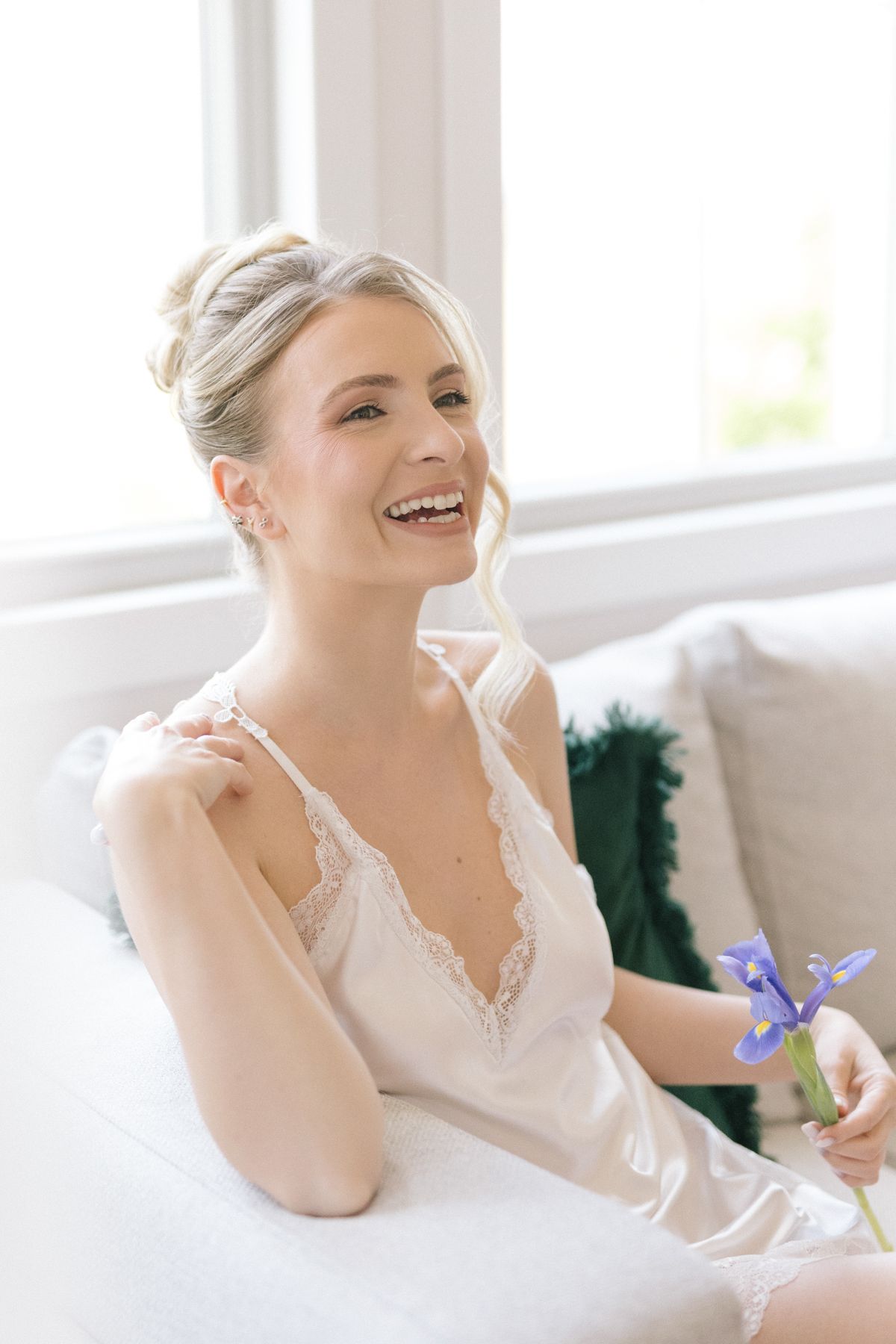 Series of intimate portraits with person holding purple iris flower on white couch.