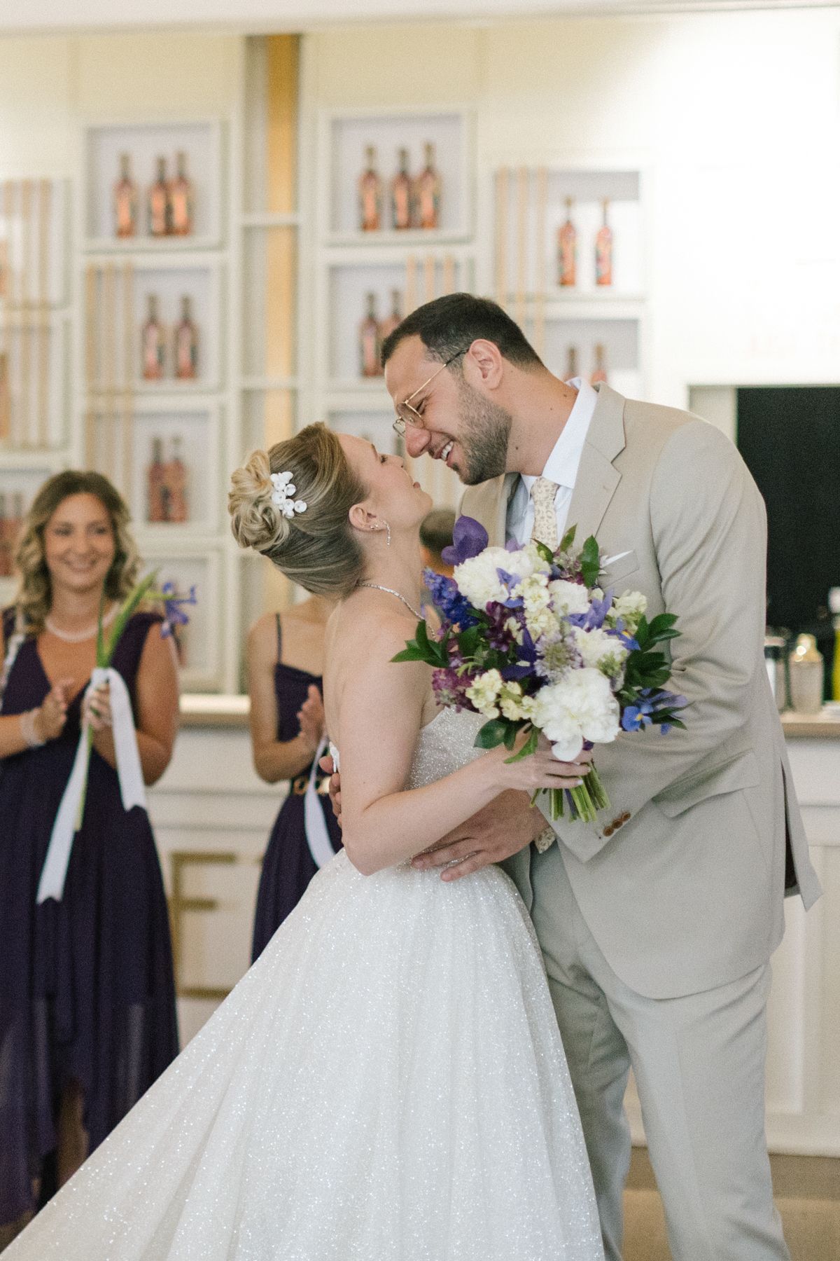 Romantic first dance moment at a wedding with bridesmaids in navy dresses watching.