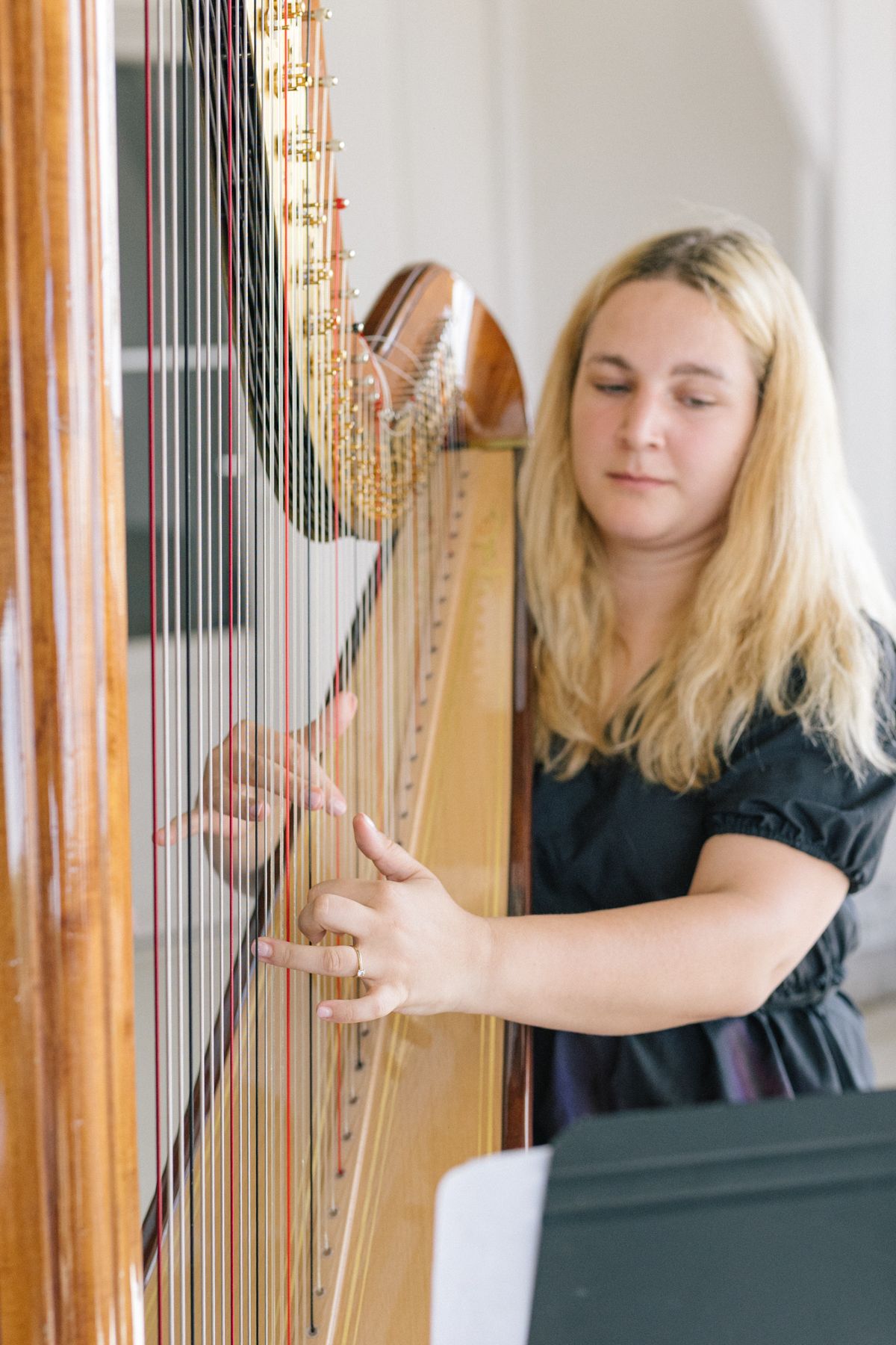 A musician playing a golden harp during an event performance.