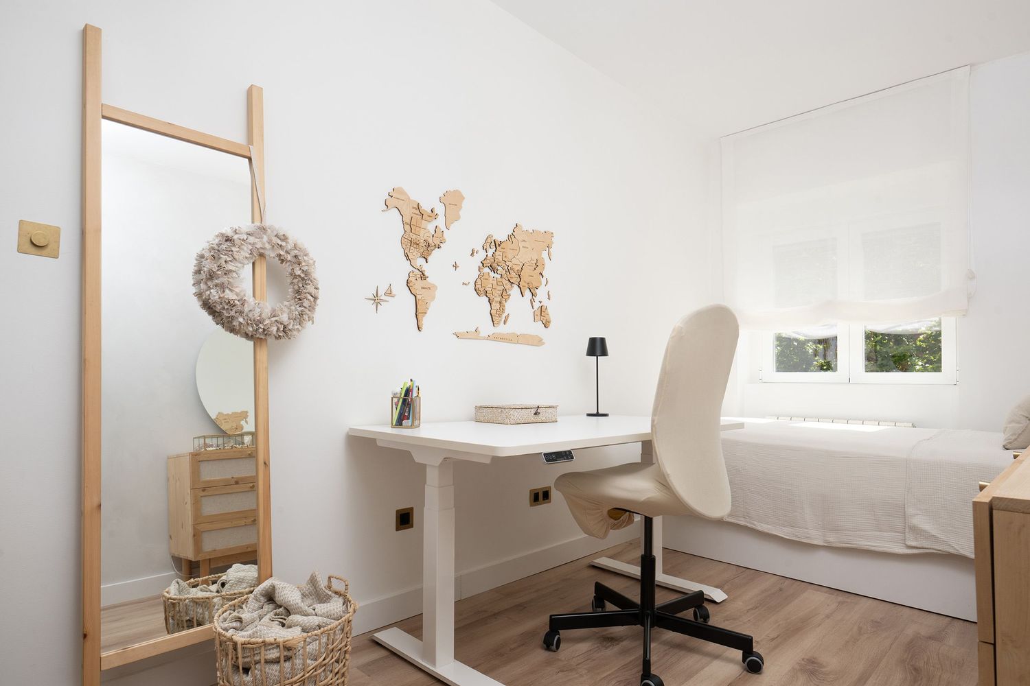 A minimalist white massage therapy room with bamboo ladder, treatment table, and natural decor elements.