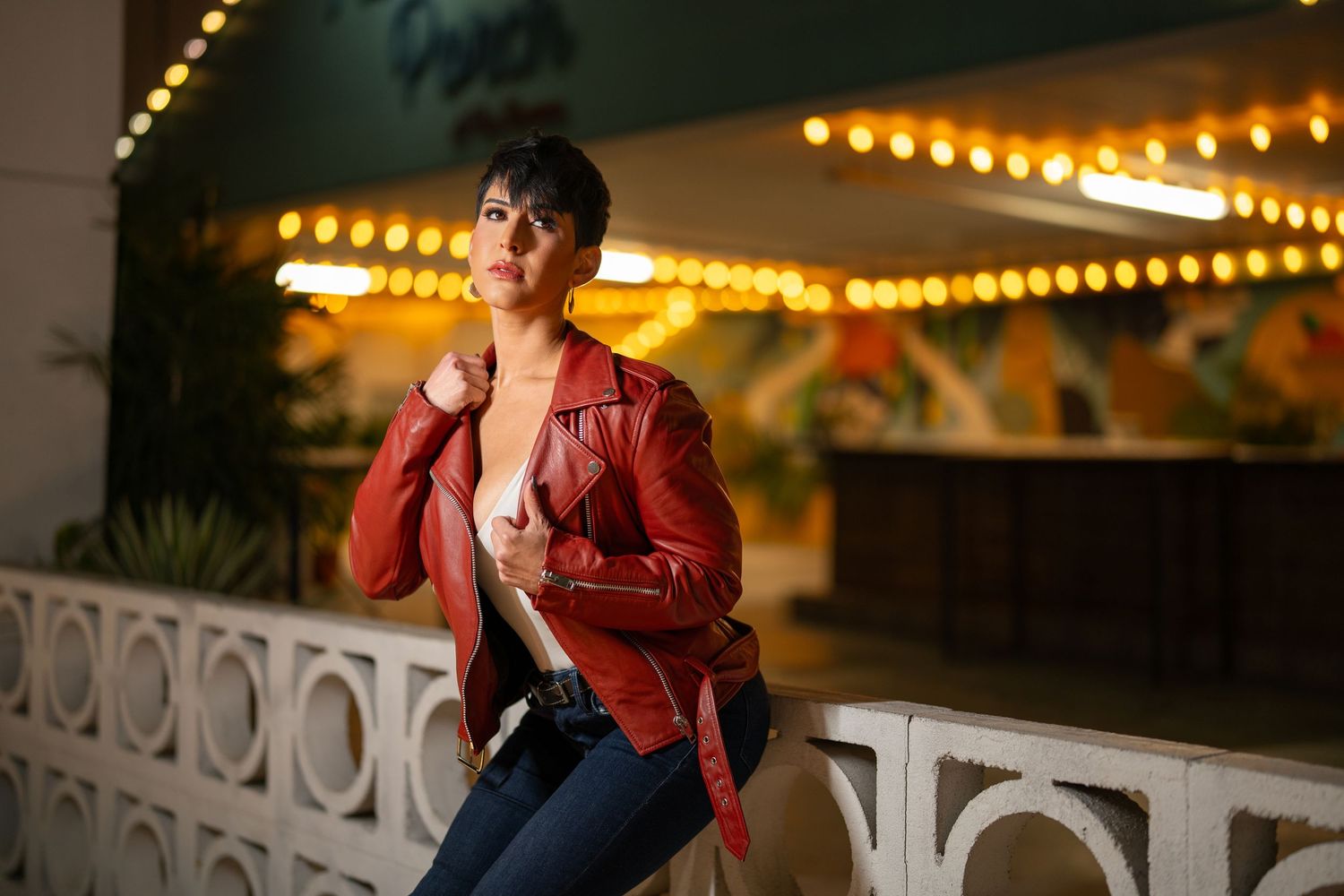 Orlando creative portrait photographer Ray Alvarez — cinematic outdoor editorial portrait of woman in red leather jacket with bokeh string l