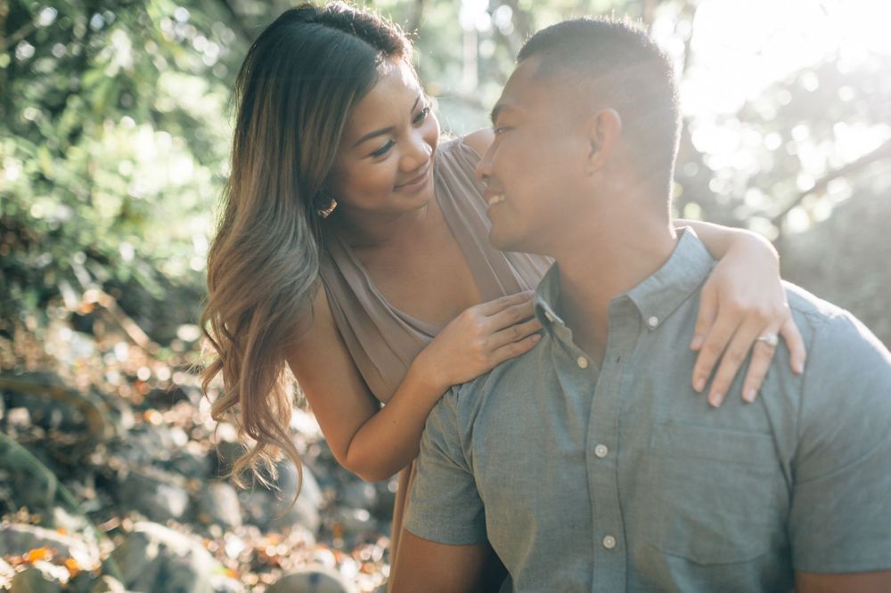 A couple exchanges affectionate glances while sitting together in natural sunlight.