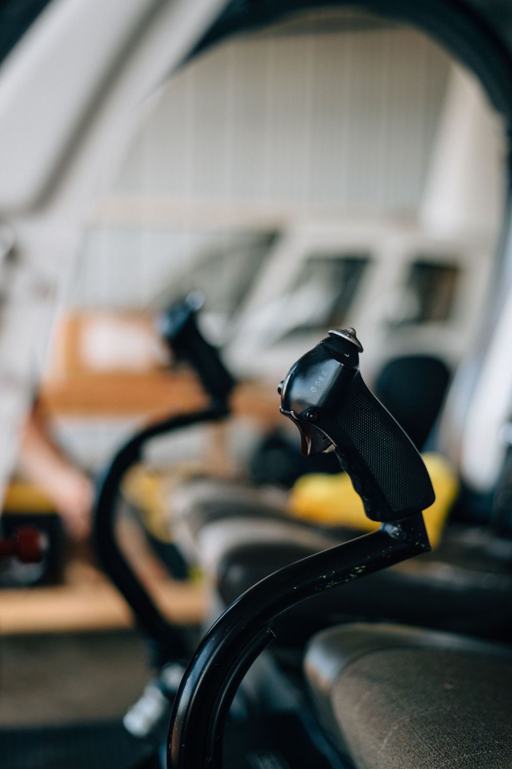 Silhouetted aircraft controls and switches against a blurred background in an airplane cockpit.