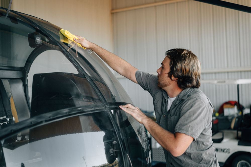 Maintenance being performed on a small aircraft in a hangar setting.