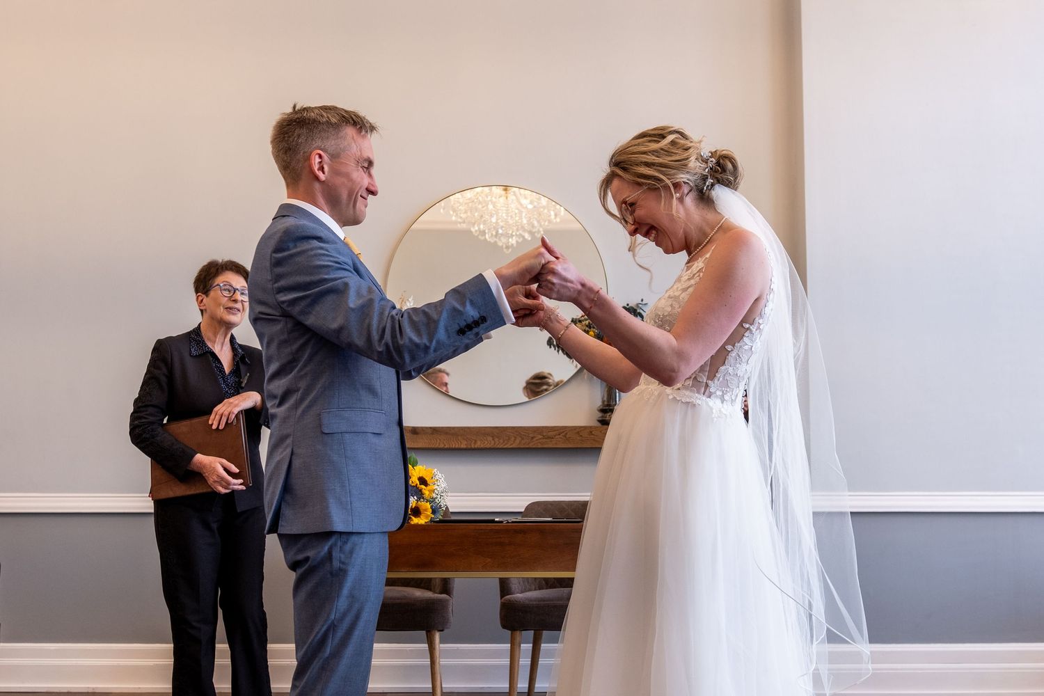 A couple in wedding attire shares a joyful moment together in Room 99 at Islington Town Hall