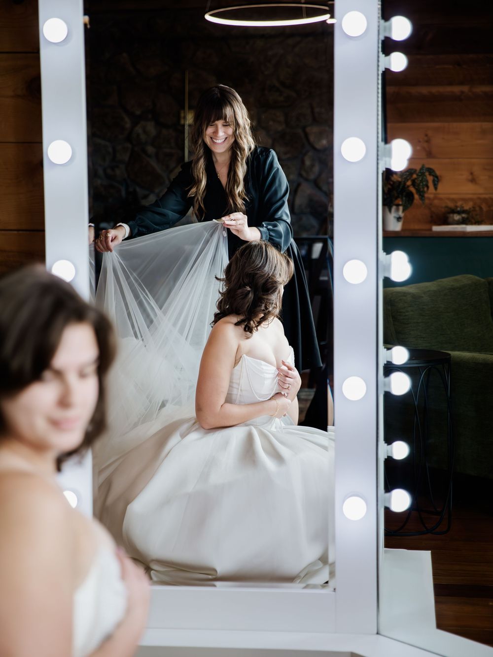 Bridal preparation scene with illuminated makeup mirror and flowing white dress.