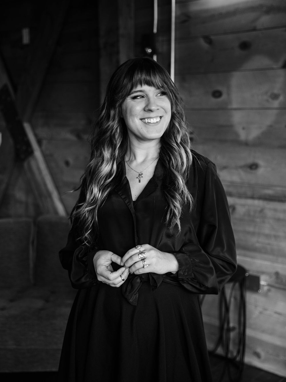 A series of black and white portraits showing joyful expressions and laughter in a rustic wooden setting.