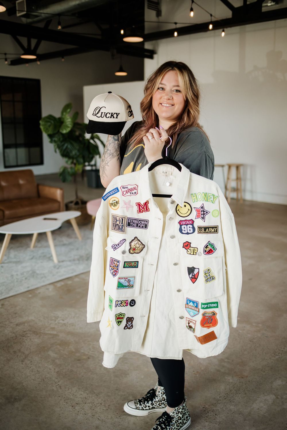 A white denim jacket covered in colorful patches and pins displayed in multiple angles.