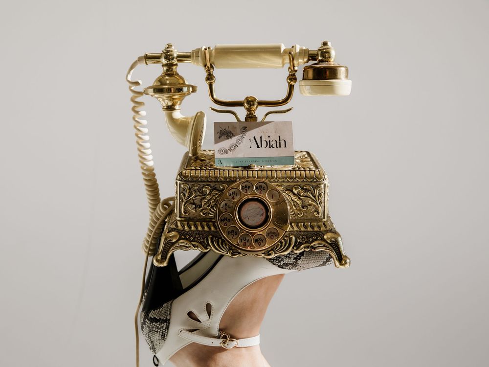 Vintage-style ornate gold telephone photographed against a light background.