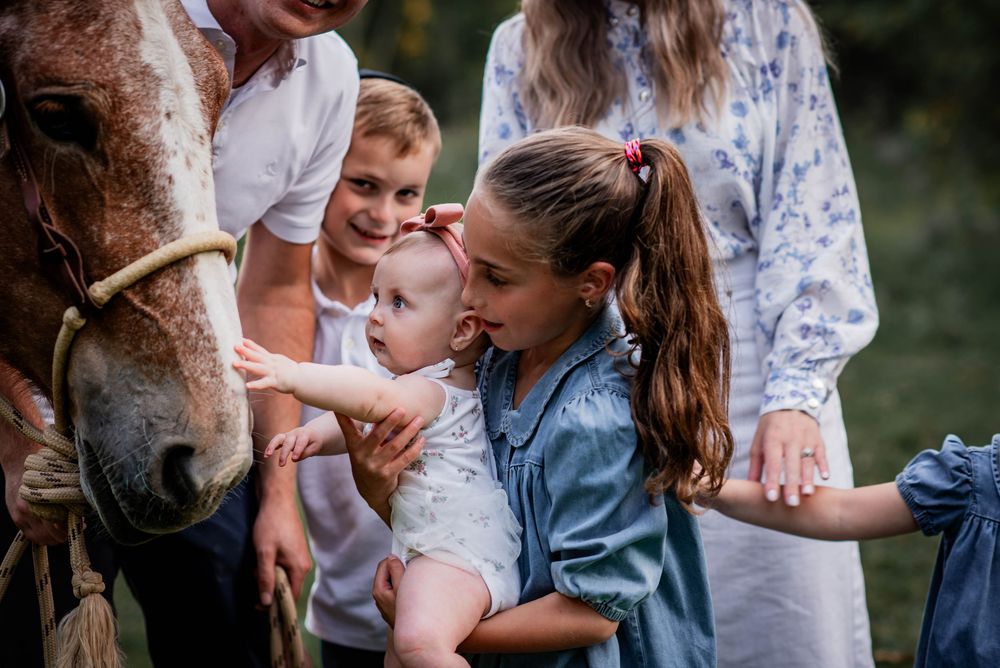 Ontario family photographer capturing children and a baby meeting a horse in Bolsover.