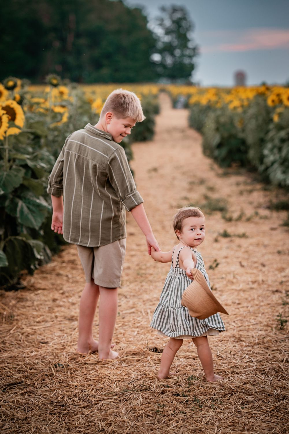 Siblings photographed during an evening family photography session after rainfall at a sunflower farm in Beaverton, Ontario.