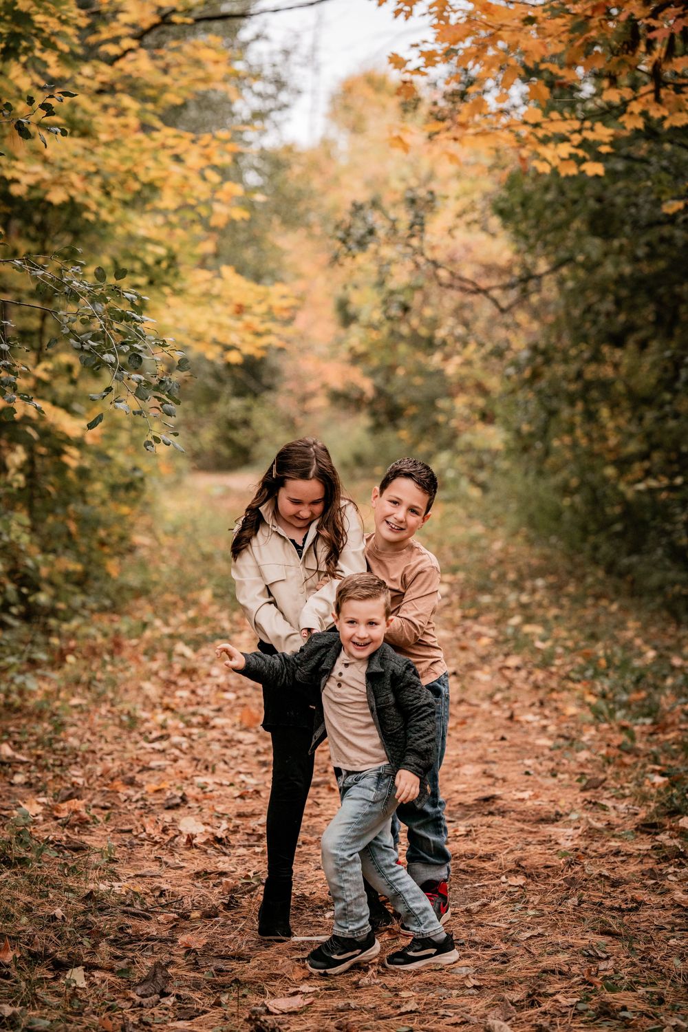 Children having fun during a fall family photography session in the York Regional Forest near Pefferlaw, Ontario.
