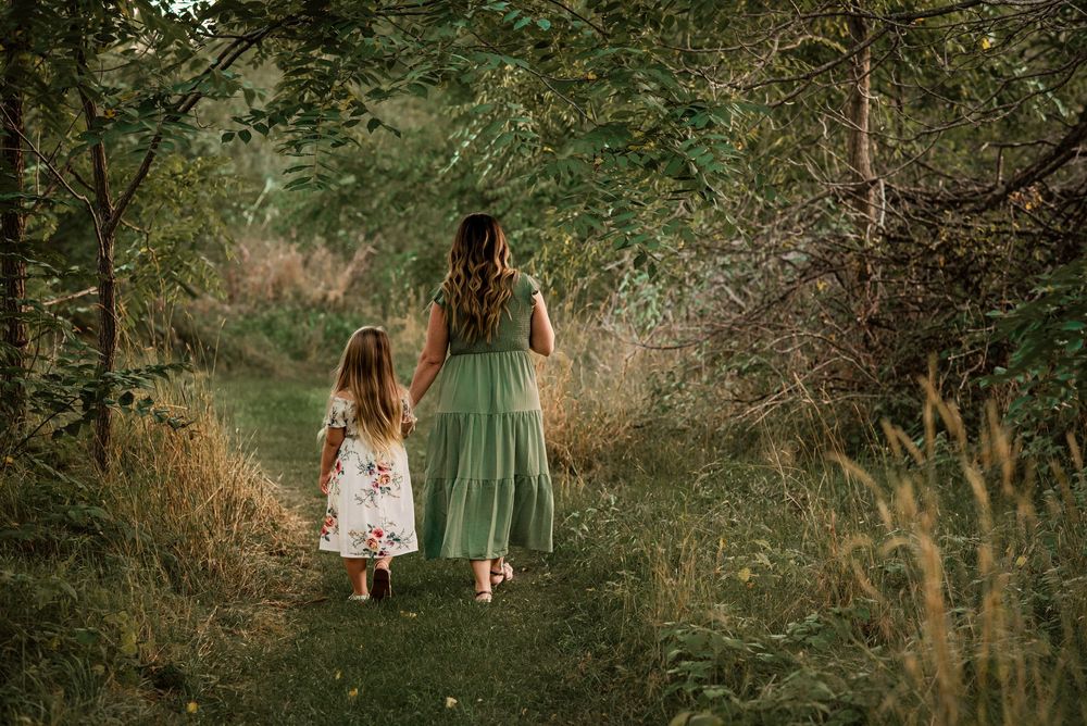 Family photography session capturing a mother and daughter walking along a trail in Beaverton, Ontario.