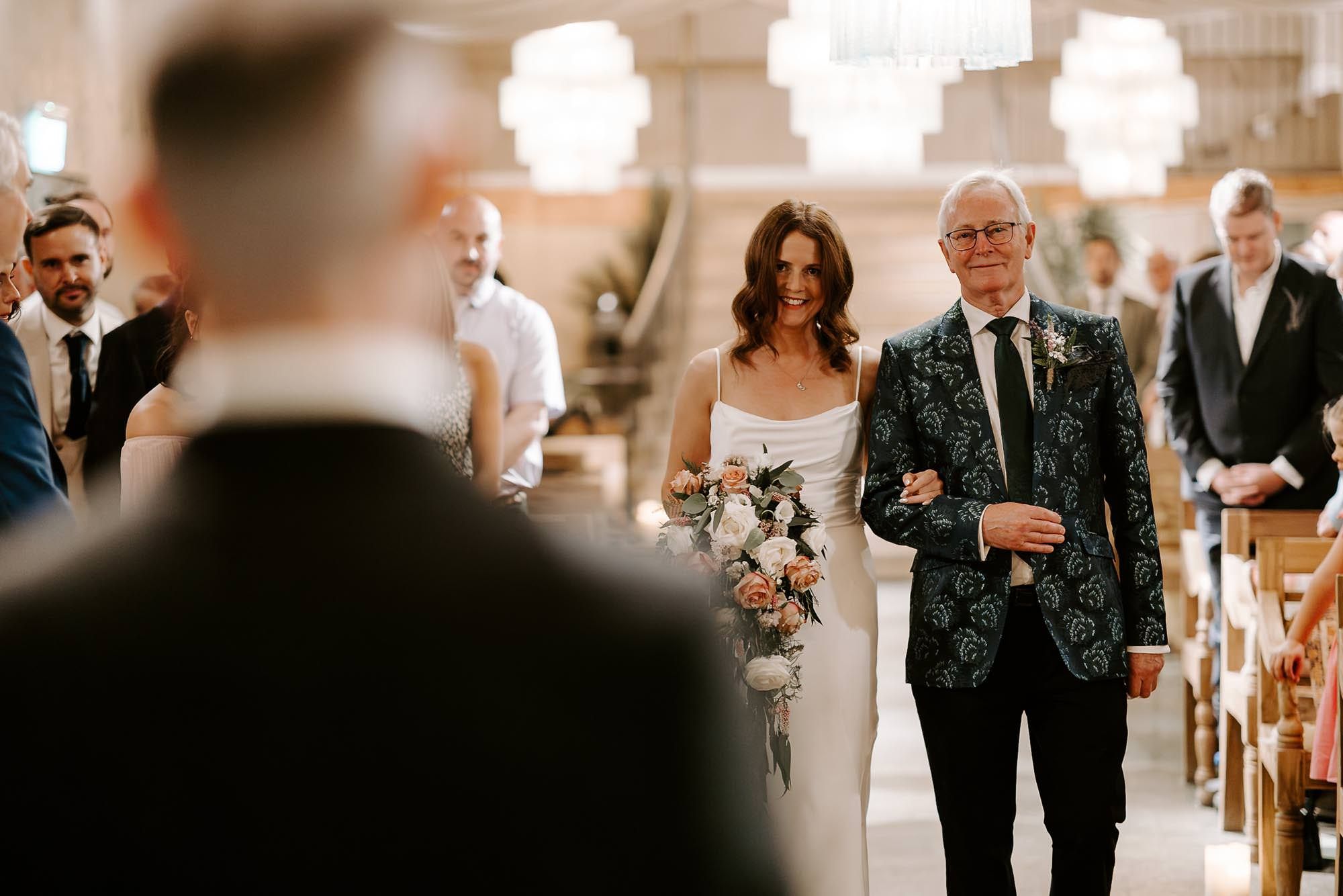 A series of wedding ceremony moments in a church showing the processional and recessional with guests in attendance.